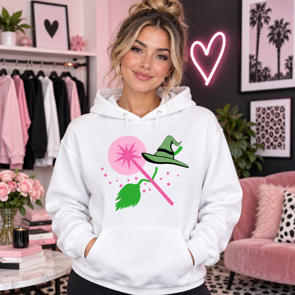 Pink wand and witch essentials design on white hoodie model